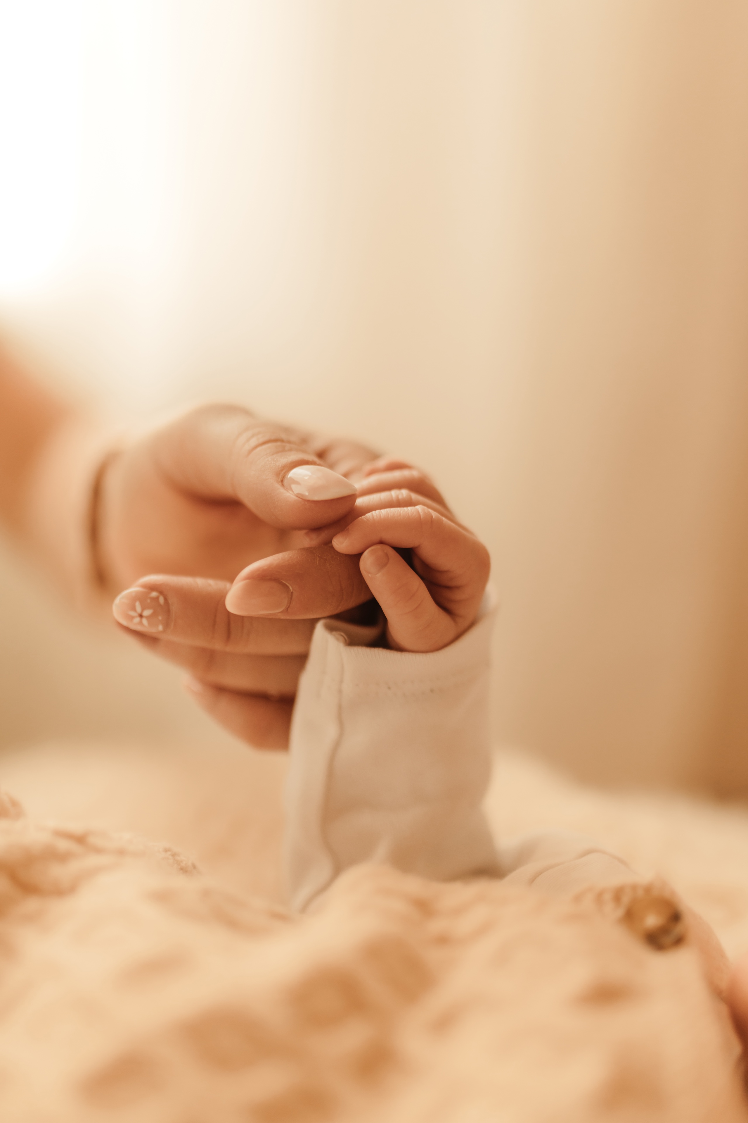 Babyhand umklammert den Finger der Mutter