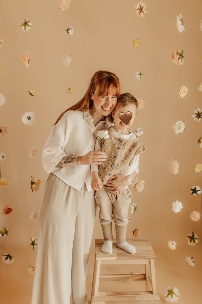 Mutter und Kind vor Blütenwand